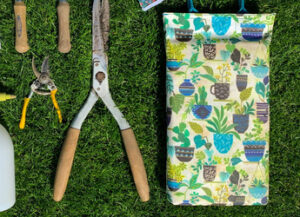Foam kneeling pad laying in the grass along with other garden tools